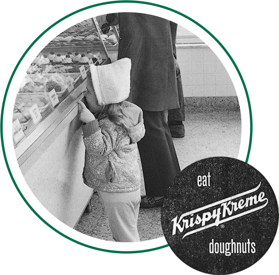 Child looking at doughnuts and Eat Krispy Kreme Doughnuts sign